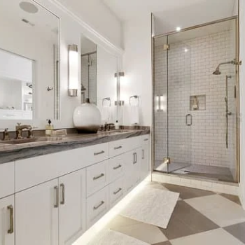 Image of a renovated bathroom in Fort Mill, SC, featuring warm tones and a subway tile pattern in the shower. The bathroom showcases a modern and inviting design, with elegant finishes and fixtures, including a sleek vanity and mirror, a luxurious bathtub, and a spacious shower. The warm tones used in the bathroom create a cozy and welcoming atmosphere.